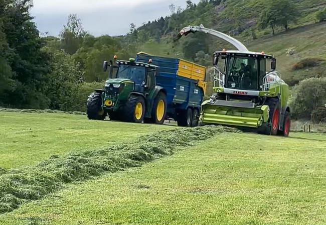 tractor and combine harvester working in a field